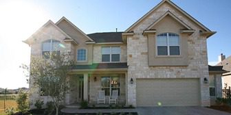 A large house with two white chairs in front of it.