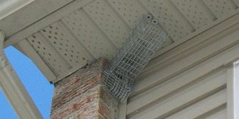 A metal object hanging from the side of a building.